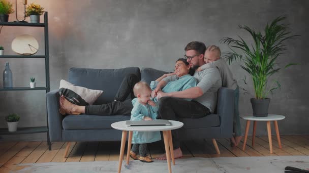 Młoda rodzina bawiąca się razem na kanapie. szczęśliwa rodzina. komfort w domu. — Wideo stockowe
