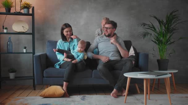 Jonge familie speelt samen op de bank. Een gelukkig gezin. comfort thuis. — Stockvideo