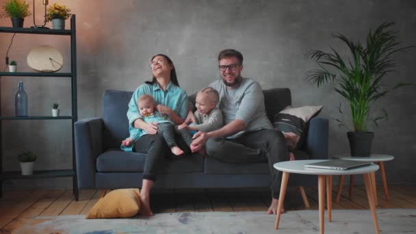 Jeune famille jouant ensemble sur le canapé. famille heureuse. confort à domicile . — Video