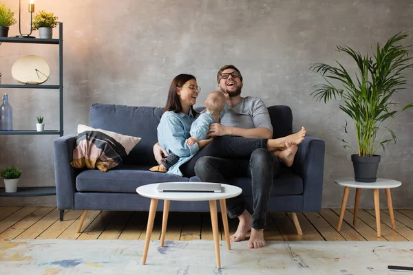 Joven familia jugando juntos en el sofá. familia feliz. comodidad en el hogar . — Foto de Stock