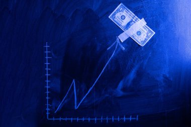 Tahtaya dolar büyüme grafiği çizilmiş. Yatırım kavramları ve ilgi alanları iş büyümesi. Dolardan oluşan yükselen grafik.