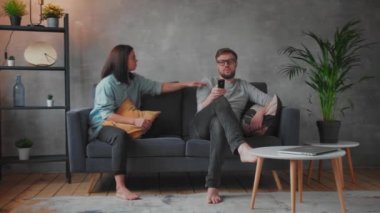 Kanepede oturan genç bir çift. Adam televizyon izliyor. Genç kadın kocasını arıyor, duymuyor. Küçük çocuk televizyonun önünde oynuyor..