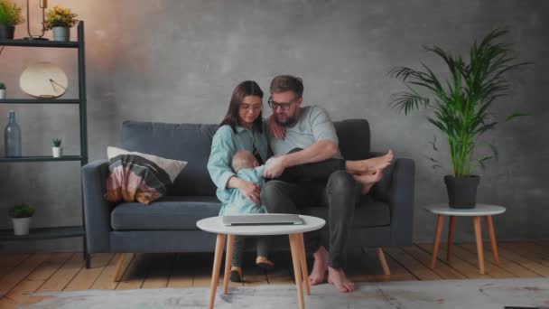 Fiatal család játszik együtt a kanapén. Boldog család. otthoni kényelem. — Stock videók