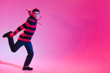 Jumperlı Genç Adam Stüdyoda Çağdaş Dans Ediyor. Breakdance. Dans okulu posteri. Uzayı kopyala Savaş yarışması duyurusu. Pembe ve Mavi Arkaplan.