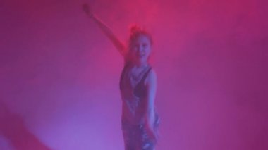 Stüdyoda renkli neon bir arka planda dans eden zarif genç bir kız. Müzik dj poster tasarımı.