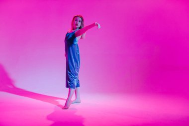 Stüdyoda renkli neon bir arka planda dans eden zarif genç bir kız. Müzik dj poster tasarımı.