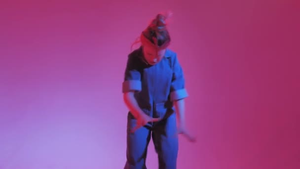 밝은 네온 배경의 젊은 스타일의 소녀 가 스튜디오에서 춤을 추고 있습니다. 음악 DJ 포스터 디자인. — 비디오