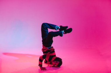 Jumperlı Genç Adam Stüdyoda Çağdaş Dans Ediyor. Breakdance. Dans okulu posteri. Uzayı kopyala Savaş yarışması duyurusu. Pembe ve Mavi Arkaplan.