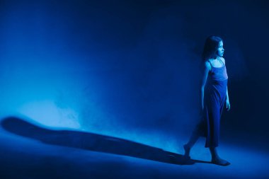 Stüdyoda renkli neon bir arka planda dans eden zarif genç bir kız. Klasik dansçı..