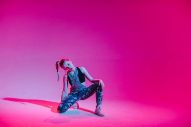 Stüdyoda renkli neon bir arka planda dans eden zarif genç bir kız. Müzik dj poster tasarımı.