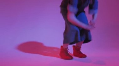 Stüdyoda renkli neon bir arka planda dans eden zarif genç bir kız. Müzik dj poster tasarımı.