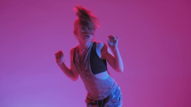 Young stylish girl dancing in the Studio on a colored neon background. Music dj poster design. — ストック動画