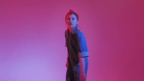 Ung snygg flicka dans i studion på en färgad neon bakgrund. Musik dj affisch design. — Stockvideo