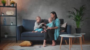 Genç Anne Kanepede Çocuklarla Oynuyor. Mutlu bir aile. ev konforu.