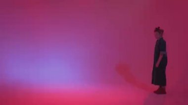 Stüdyoda renkli neon bir arka planda dans eden zarif genç bir kız. Müzik dj poster tasarımı.