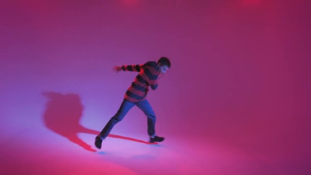 Junger Mann im Pullover tanzt zeitgenössischen Tanz im Studio. Breakdance. Tanzschulplakat. Kopierraum. Kampfansage. Rosa und blauer Hintergrund. — Stockvideo