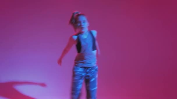 Молодая стильная девушка танцует в студии на цветном неоновом фоне. Дизайн музыкального плаката . — стоковое видео