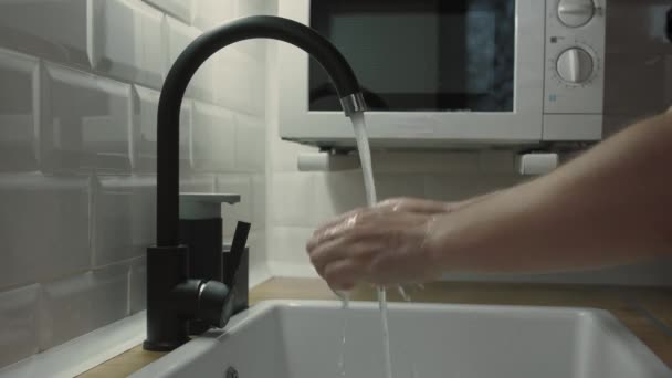 Hands of man wash their hands in a sink with foam to wash the skin and water flows through the hands. Concept of health, cleaning and preventing germs and coronavirus from contacting hands. — Stock Video