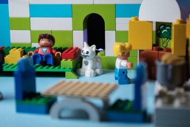 Oyuncak adam kanepede televizyon izliyor. Bir kadın yemek hazırlar. Sosyal Fotoğrafçılık. Evde kal.