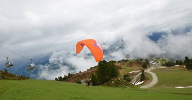 Avusturya yamaç paraşütü, bulutlar ve dağ manzarası.