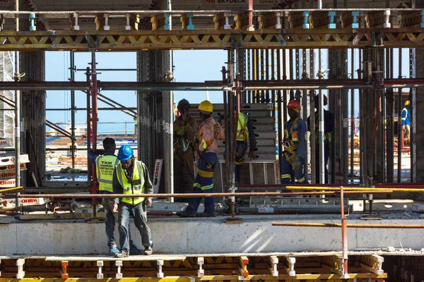 Pracowników pracujących wśród rusztowań i betonu na Contruction — Zdjęcie stockowe