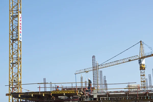 Guindaste de alta elevação e trabalhadores Woking no canteiro de obras — Fotografia de Stock