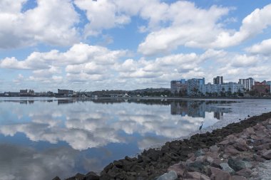 Liman düşük Tide bulutlu mavi gökyüzü yansımaları ile