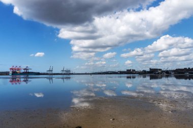 Liman düşük Tide bulutlu mavi gökyüzü yansımaları ile