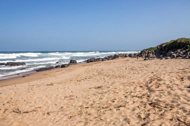 Okyanus dalgaları ve mavi gökyüzü Beach iskelesinden kayalar