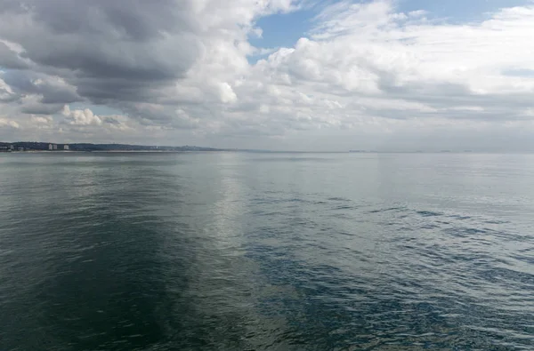 Mare calmo con riflessi di cielo blu nuvoloso — Foto Stock