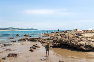 Scottburgh, erken sabah sahilde insanlar 