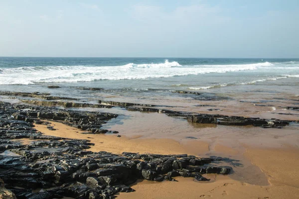 Rochas na costa do mar contra o oceano e o horizonte azul — Fotografia de Stock