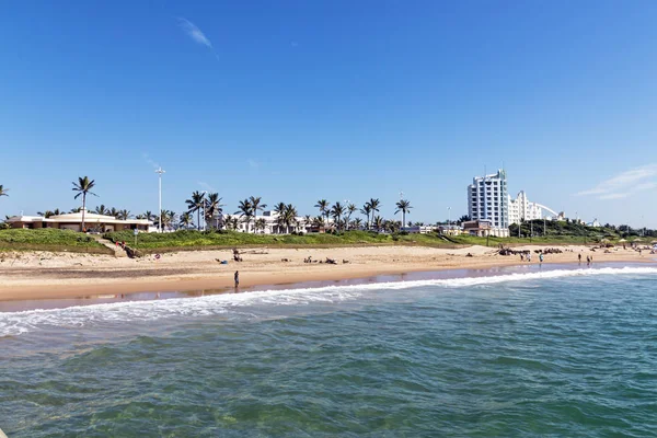 Mare e spiaggia contro edifici costieri e cielo blu — Foto Stock