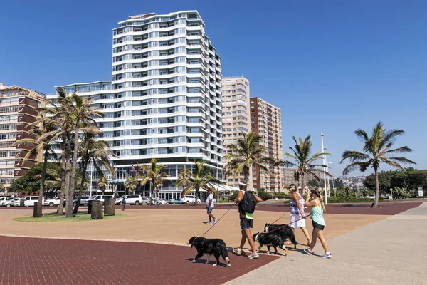 Döşeli kıyısındaki Beachfront üzerinde yürüyen insanlar — Stok fotoğraf