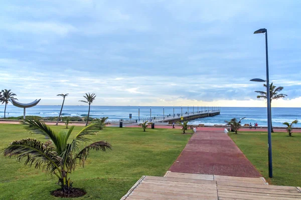 Promenada, prowadząca ku Pier Beach i niebieski Skyline zachmurzony — Zdjęcie stockowe