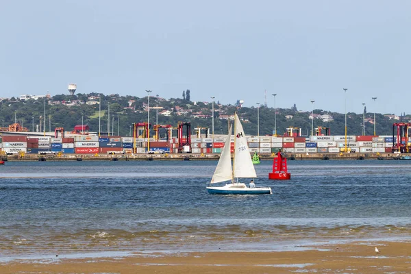 Yacht at Low Tide in Harbor Against Stacked Containers — Stock Photo, Image