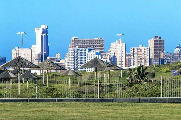 Green Lawn and Picnic Area Sunshades Against City Skyline — Stock Photo, Image