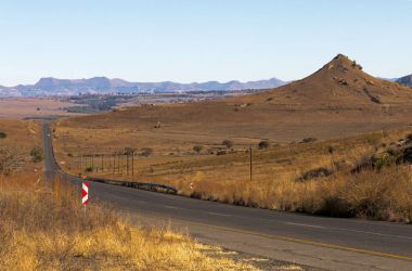 Güney Afric içinde Kuru kış manzarası ile çalışan asfalt yol