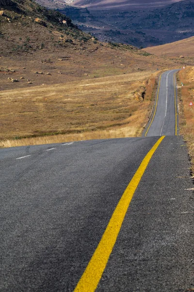 Pusty wiejskich drogi asfaltowej przebiegającej przez suchy zimowy krajobraz — Zdjęcie stockowe