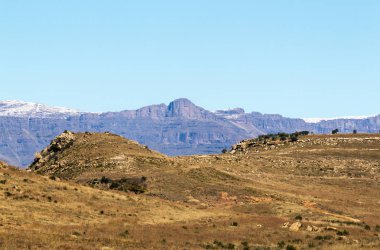 Kayalık dağ ve mavi gökyüzü karşı turuncu renkli çimen