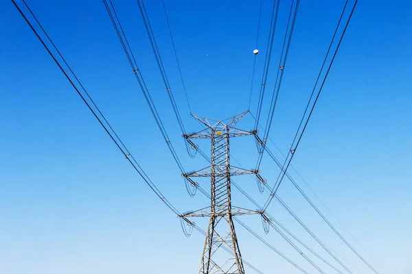 Close-up de postes elétricos Powerlines e céu azul — Fotografia de Stock