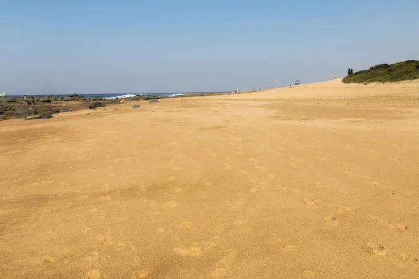 Playa de arena y costa rocosa contra el cielo azul — Foto de Stock