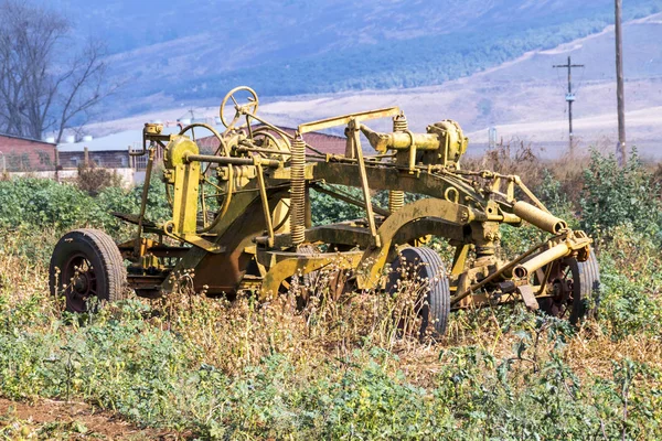 Vintage sarı çiftlik alet kırsal çiftlik manzara karşı — Stok fotoğraf