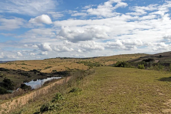 Kış otlak Hills vadiler ve mavi bulutlu gökyüzü karşı