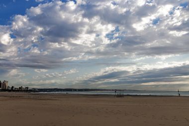 Şehir ve mavi bulutlu Skyline karşı erken futbol plaj