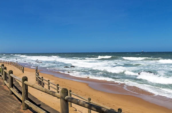 Barreira de Pólo de Madeira em frente à praia contra a paisagem costeira — Fotografia de Stock