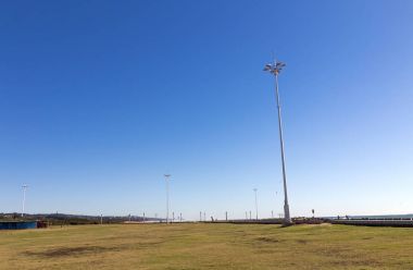  Çim eşiğinde ve uzun boylu sel lambalar ve mavi gökyüzü