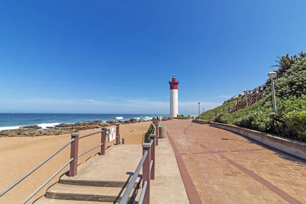 Leuchtturmlandschaft an der gepflasterten Strandpromenade — Stockfoto