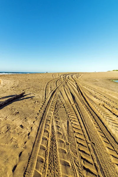 Modelli e struttura delle tracce del veicolo sulla sabbia della spiaggia — Foto Stock