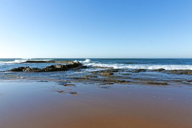 Islak pürüzsüz kıyı sahil kumu ve mavi kıyı manzarası 